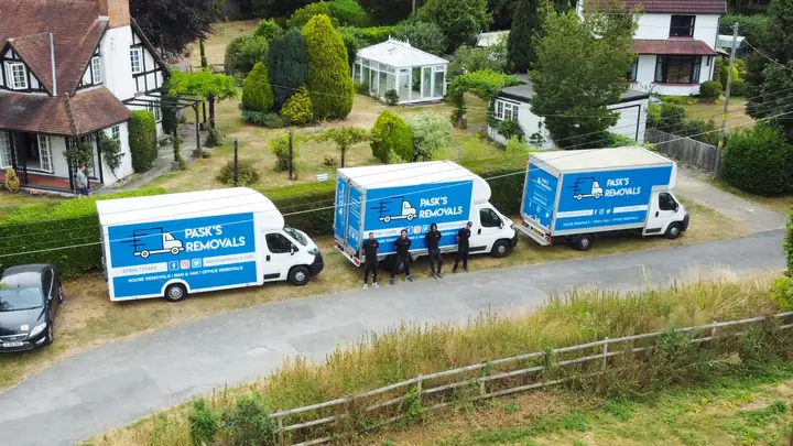 Drone view of three Pask's Removals London vans and crew outside a large detached house