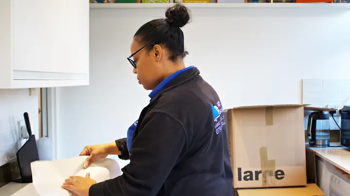 Pask's Removals London packer wrapping kitchen items in packing paper