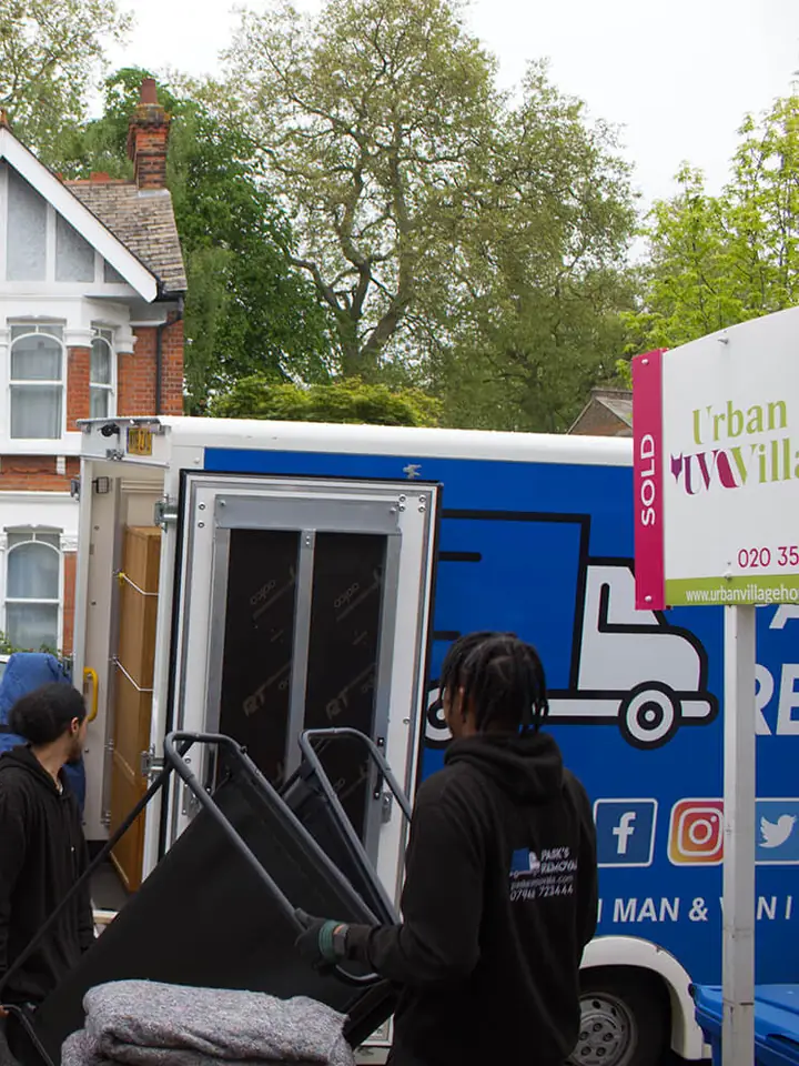 Pask's Removals London crew loading belongings into branded vans outside a semi-detached house