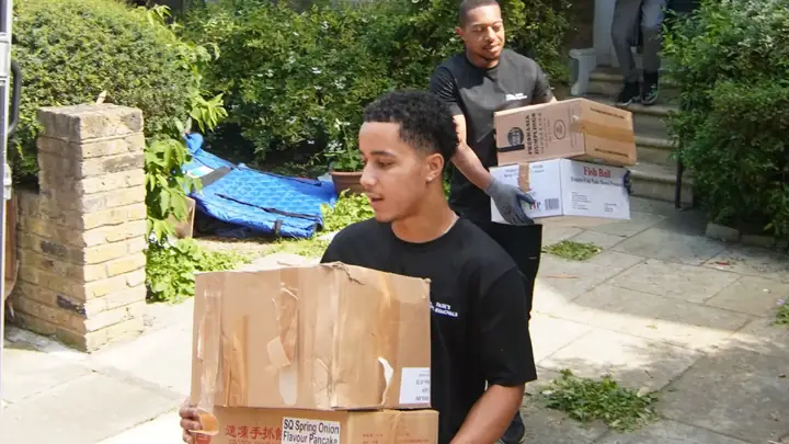 Two Pask's Removals London movers carrying cardboard boxes out of a house